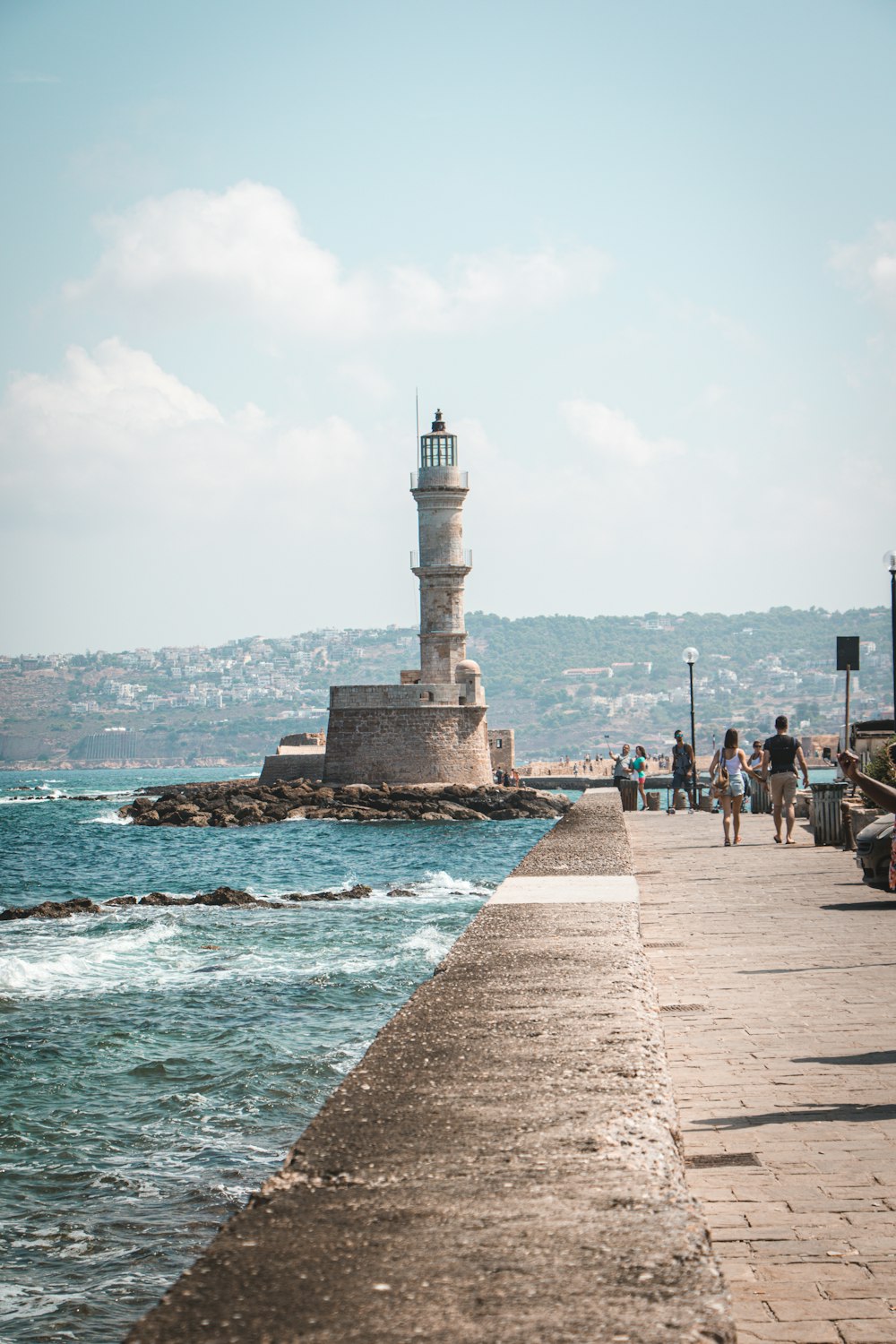 people standing near white concrete lighthouse during daytime