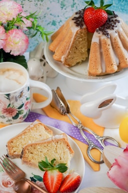 A cozy kitchen scene with a beautifully decorated cake and fresh flowers on the table.