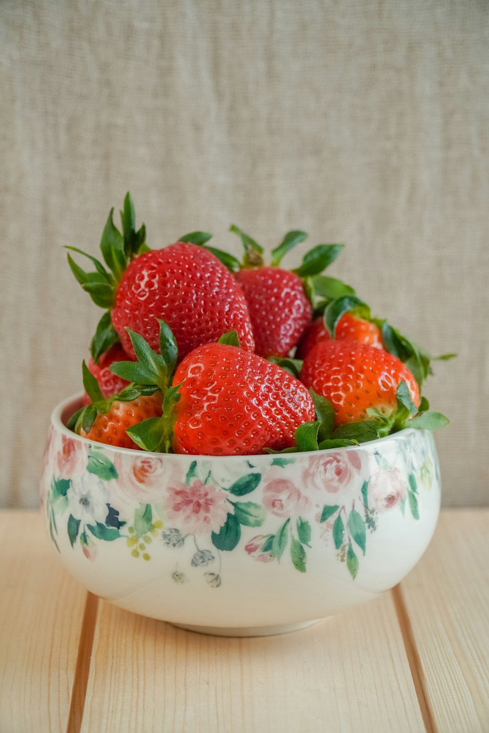 strawberries in white green and pink floral ceramic bowl