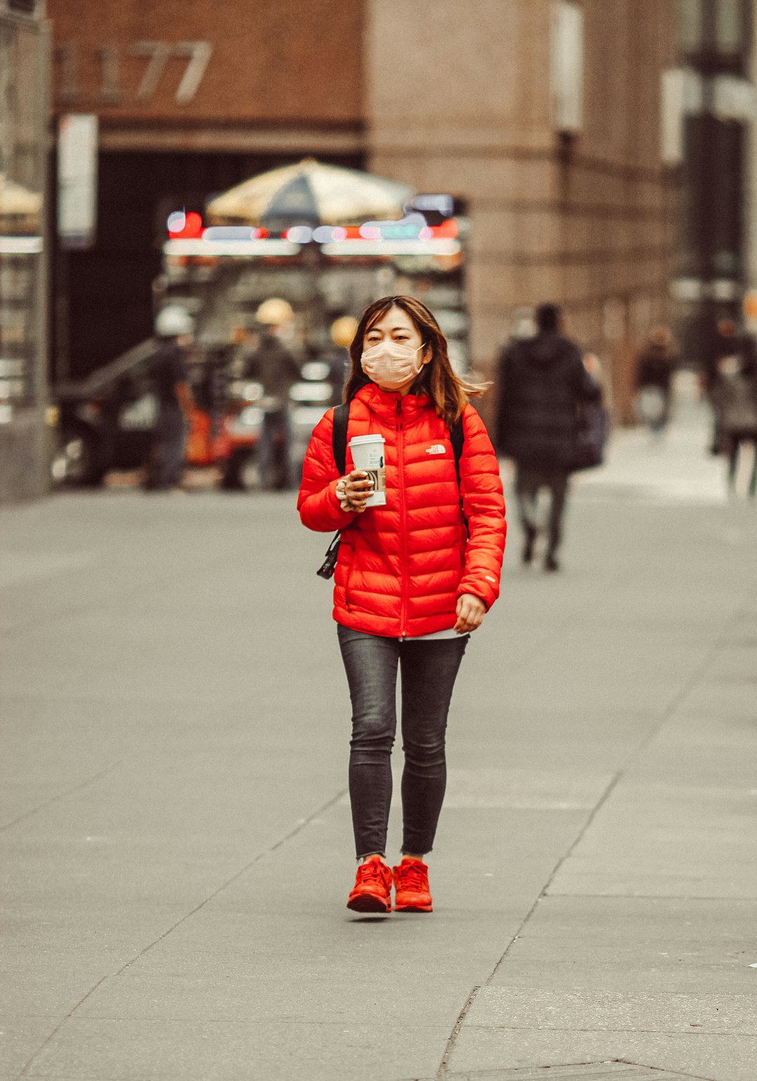 woman in red jacket standing on the street