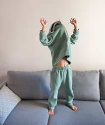 a person jumping on a couch in a living room