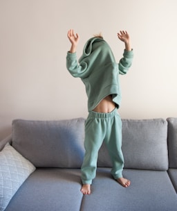 a person jumping on a couch in a living room