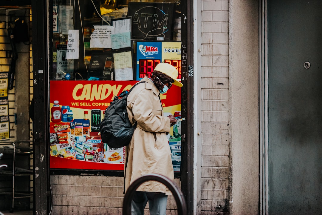 person in beige coat standing near store