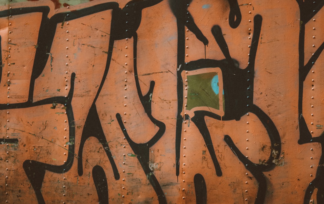 orange and black graffiti on wall