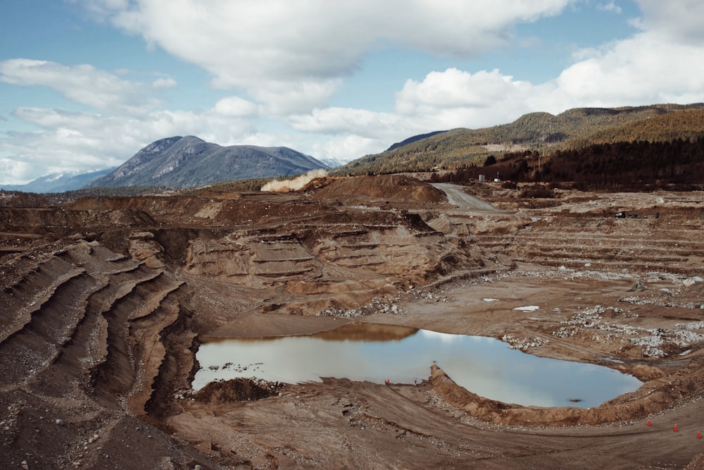 Montaña rocosa marrón cerca del lago bajo el cielo azul durante el día