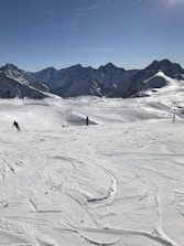 A scenic mountain landscape with skiers enjoying fresh powder snow.
