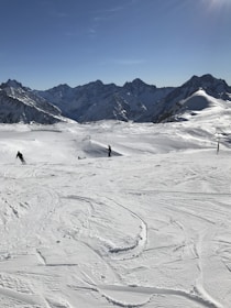 A scenic mountain landscape with skiers enjoying fresh powder snow.