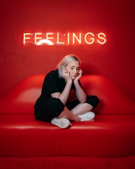 woman in black long sleeve shirt and black pants sitting on red couch