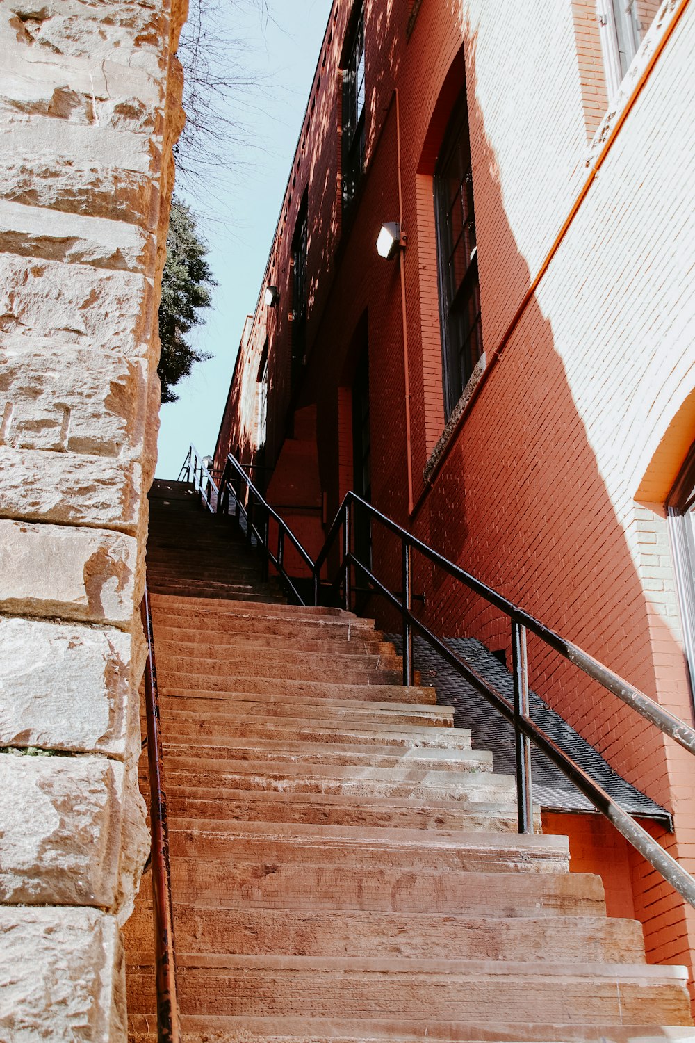 escada de concreto marrom perto da porta de madeira vermelha