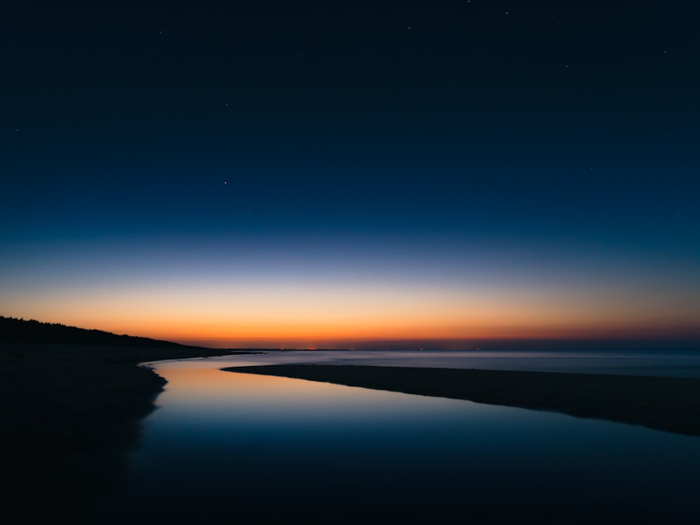 body of water under blue sky during daytime