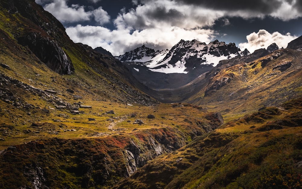 green and brown mountains under white clouds and blue sky during daytime