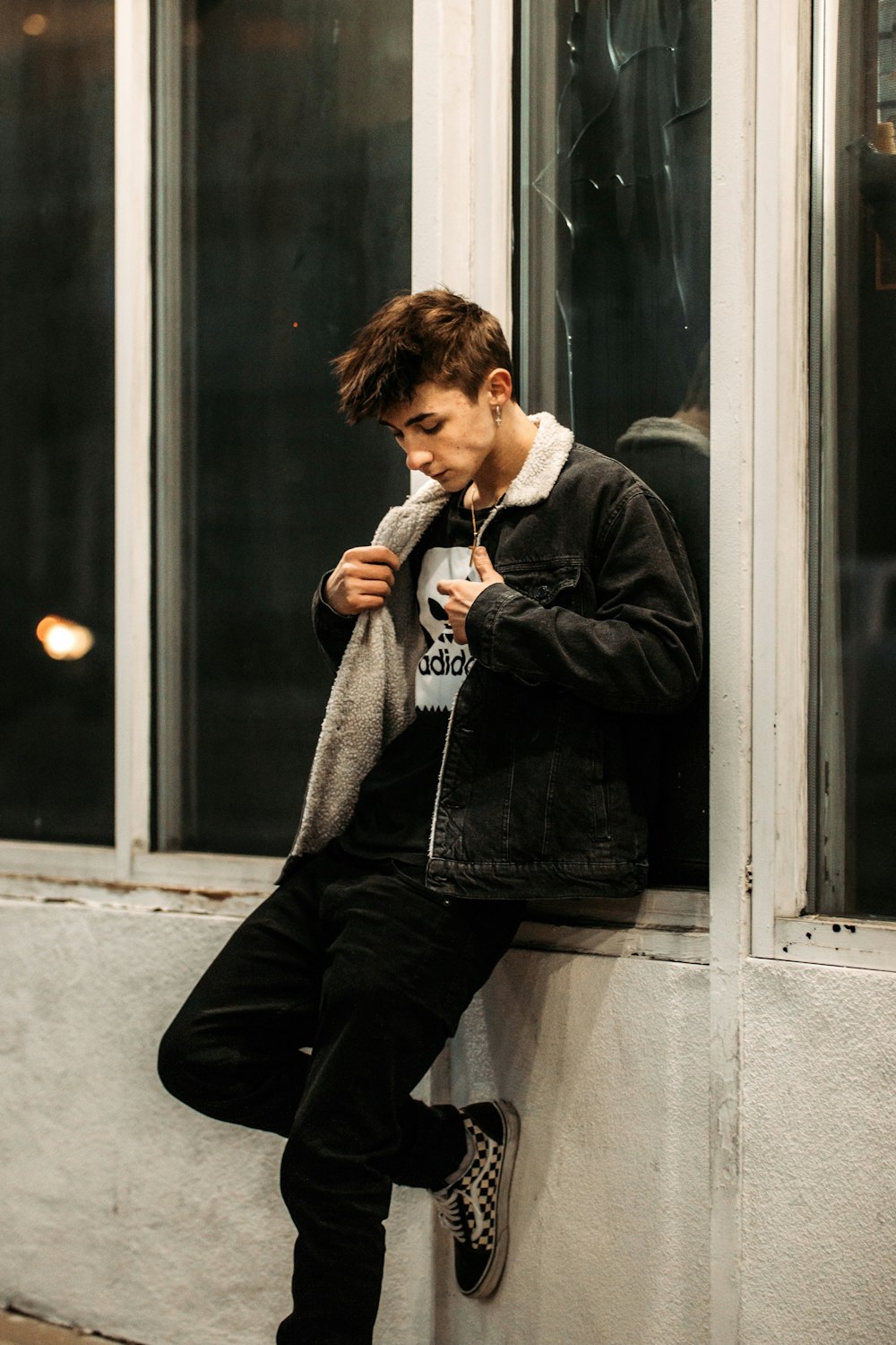 woman in black jacket and black pants sitting on window