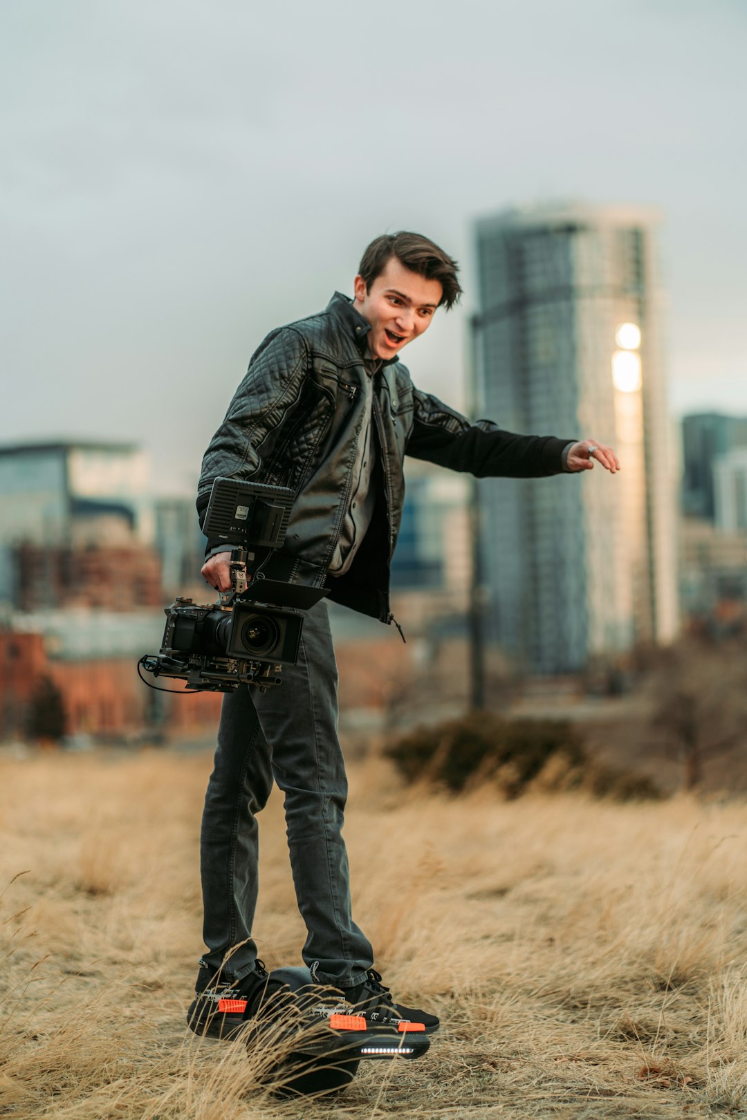 man in black jacket and black pants holding black camera