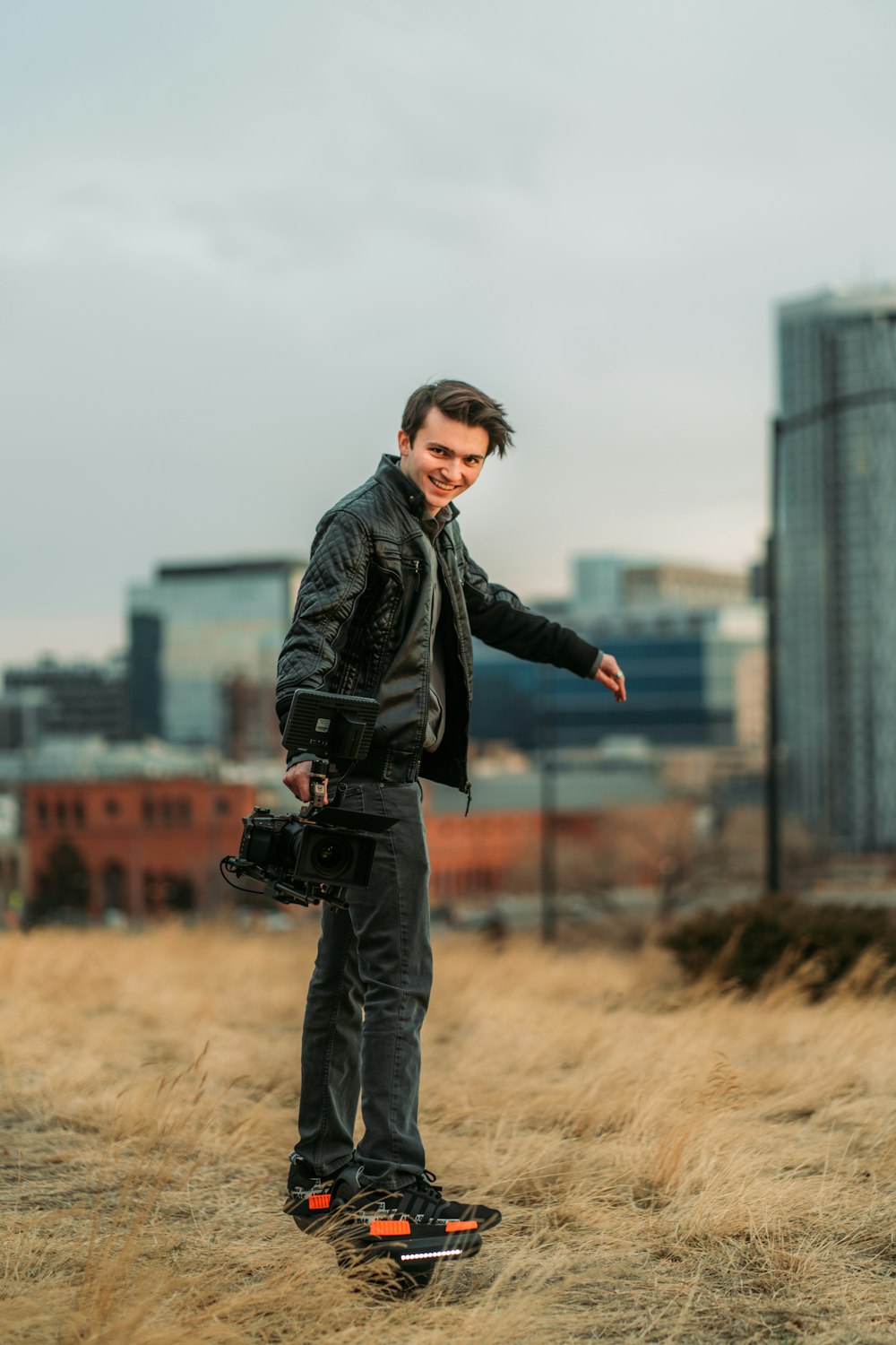 man in black leather jacket standing on brown field during daytime