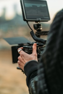 person holding black camera during daytime