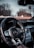 The interior of a luxury car featuring a detailed view of the steering wheel with the Mercedes-Benz logo prominently displayed. The dashboard includes modern controls and a digital display, and there is a view of the snowy landscape and trees outside through the windshield.