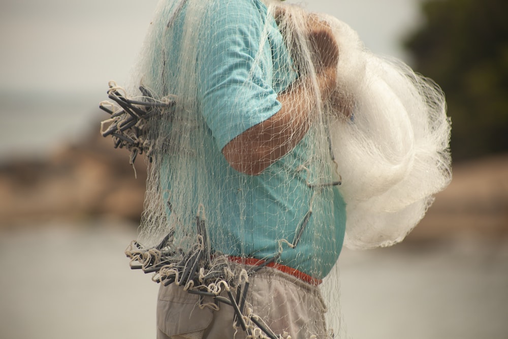 teal and white feather on persons hand