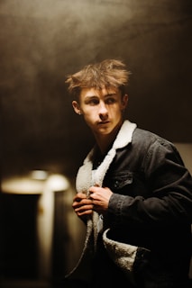 Justin Bieber looking contemplative backstage, shadows hinting at the chaos behind the scenes.