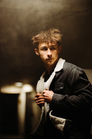 Justin Bieber looking contemplative backstage, shadows hinting at the chaos behind the scenes.