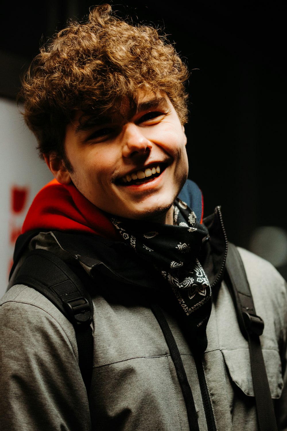 smiling man in gray and black scarf