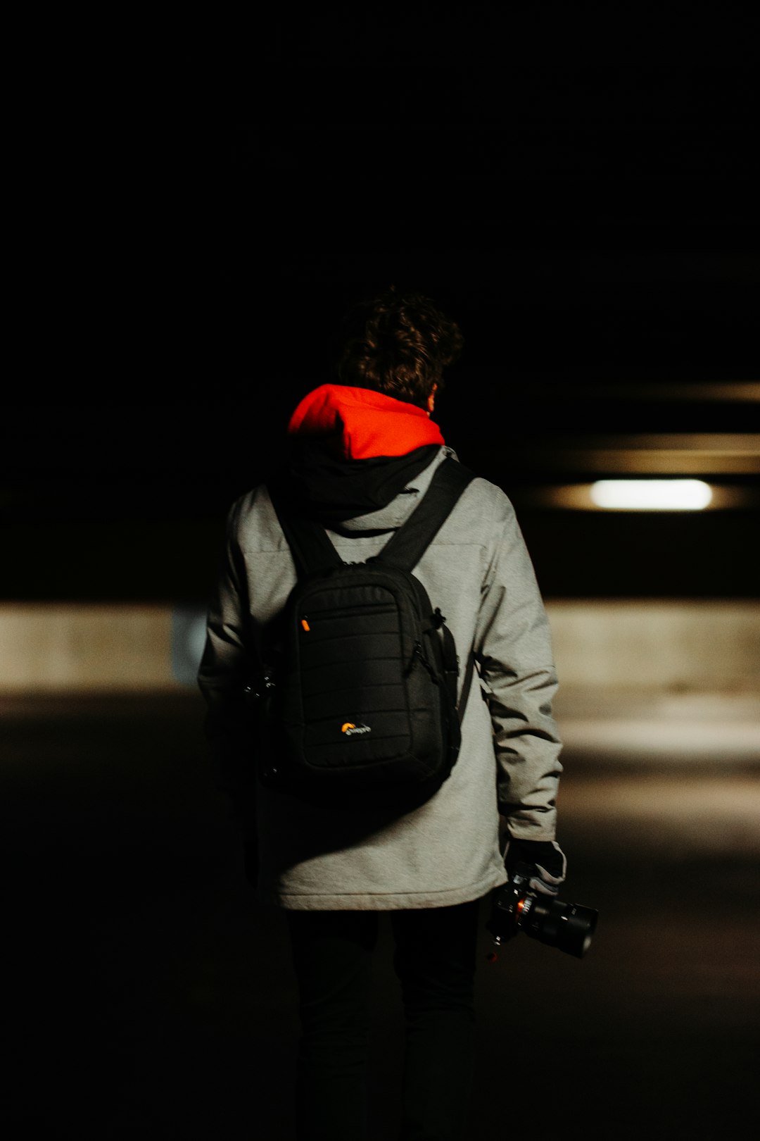 man in black and red hoodie and gray backpack