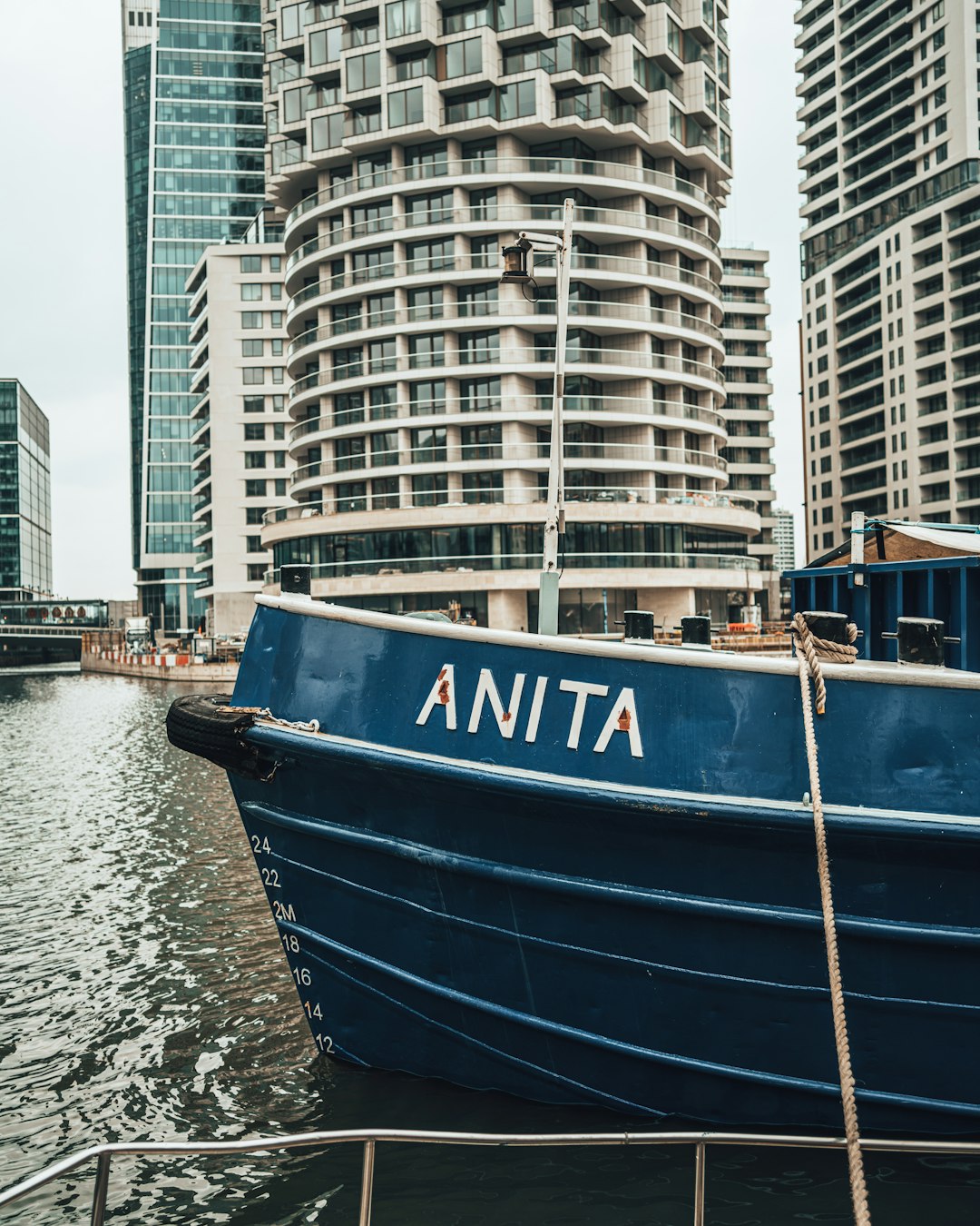 blue and white boat on water near city buildings during daytime