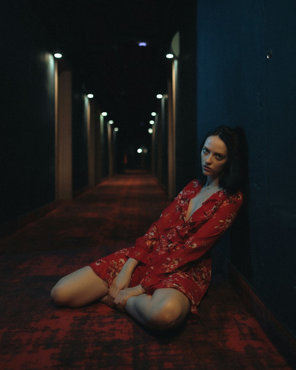 woman in red and white floral dress sitting on floor