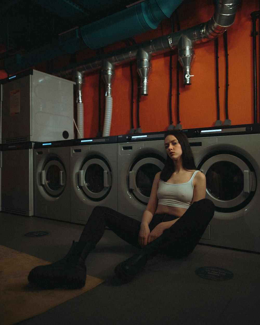 woman in black tank top and black pants sitting on red chair