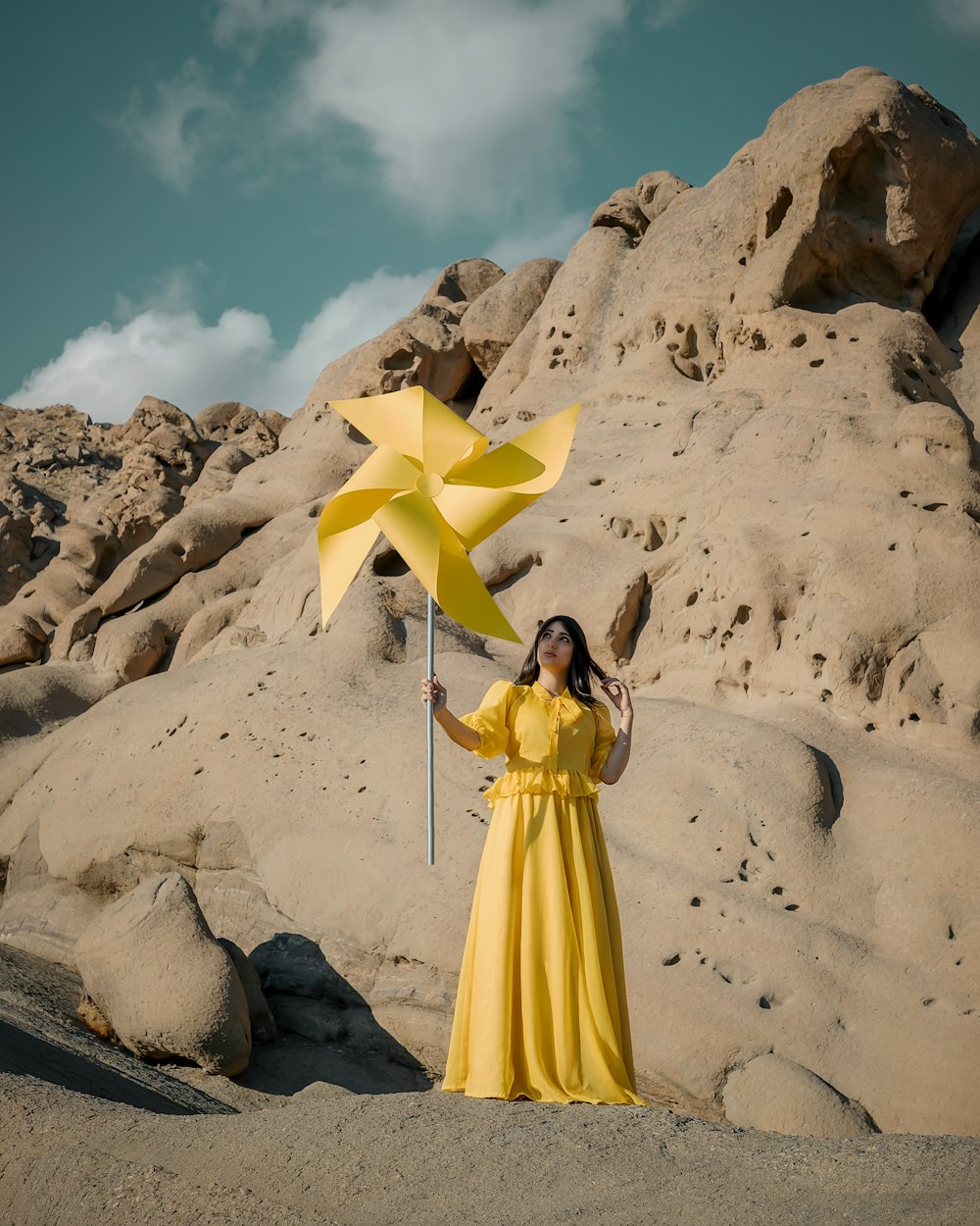 woman in yellow dress standing on white sand during daytime