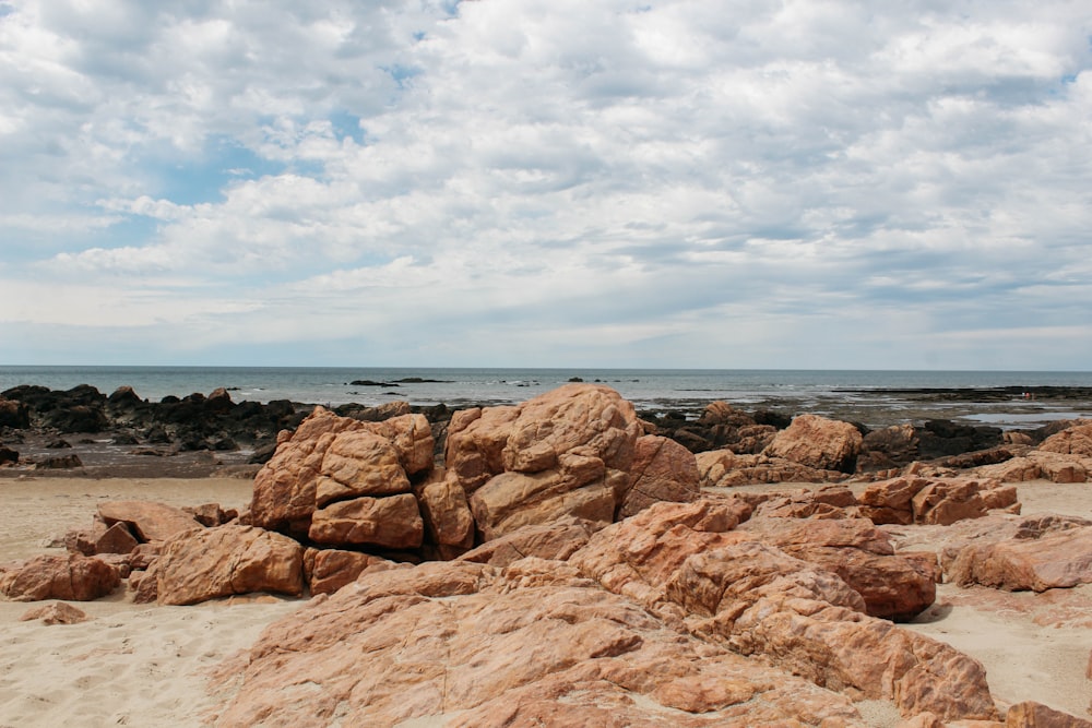 brown rock formation near body of water during daytime