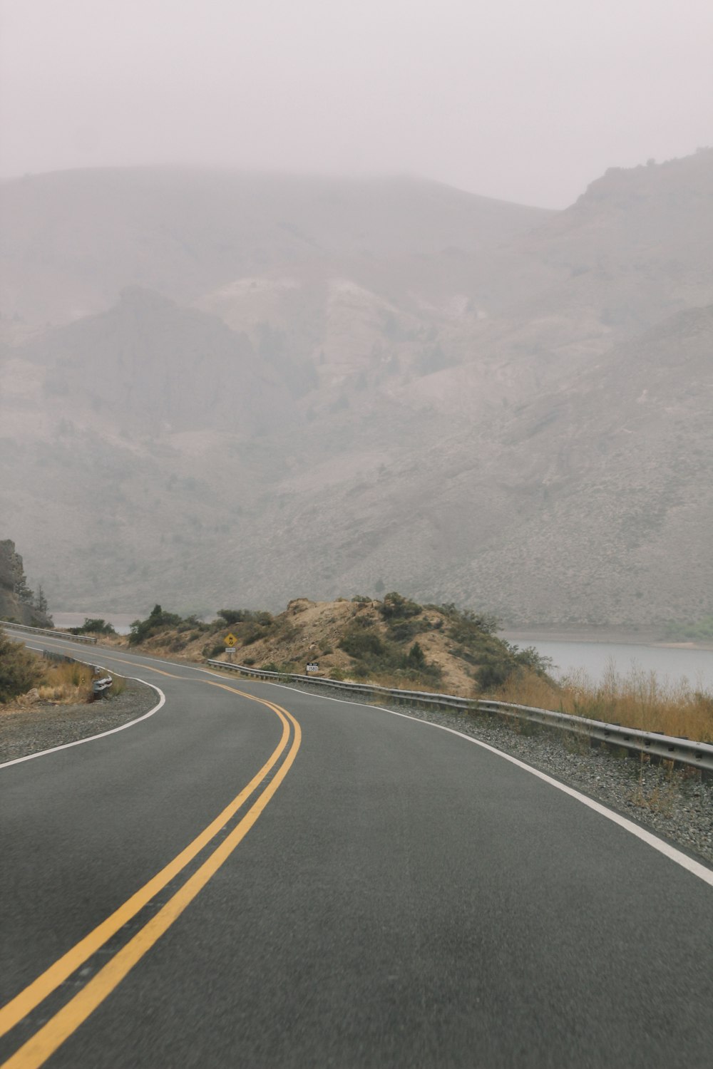 gray concrete road near mountain during daytime