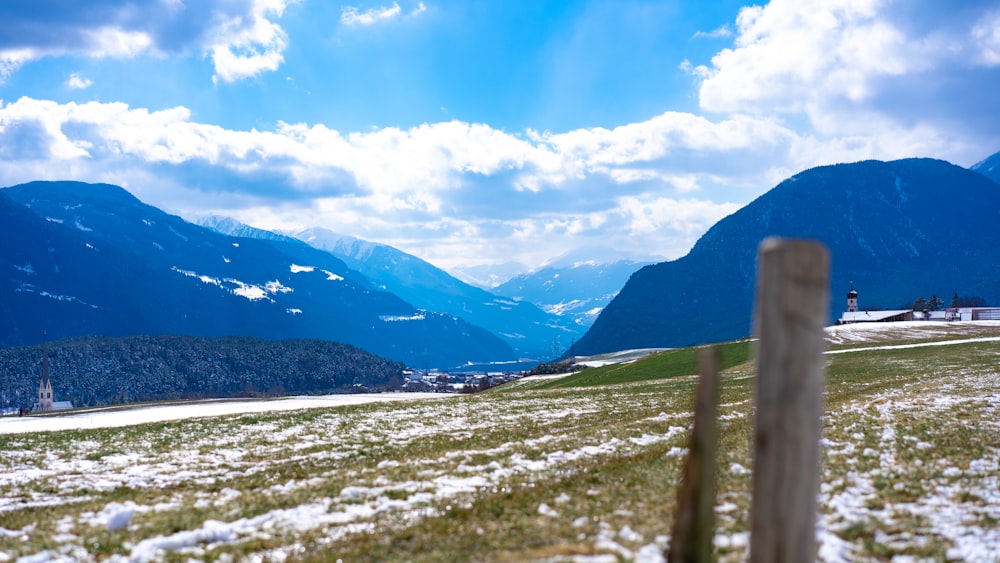 white snow covered field near mountains under blue sky during daytime