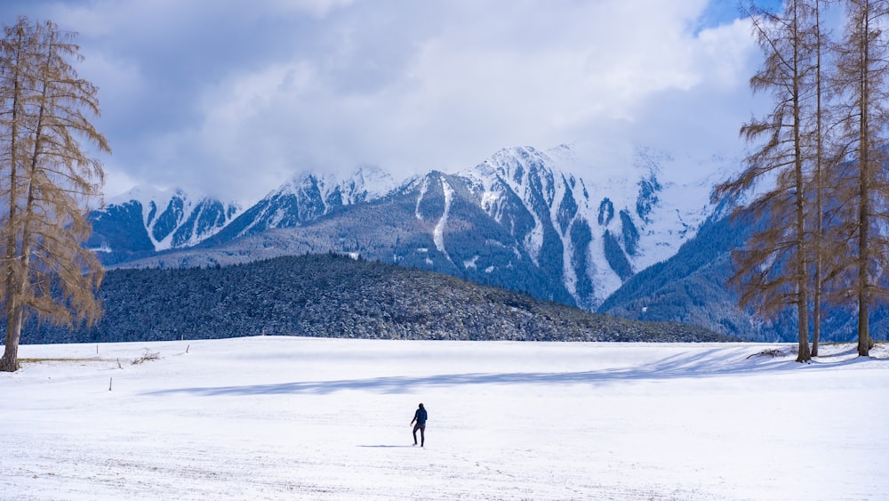 person walking on snow covered field during daytime