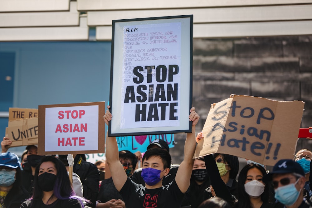 people holding white and black poster during daytime