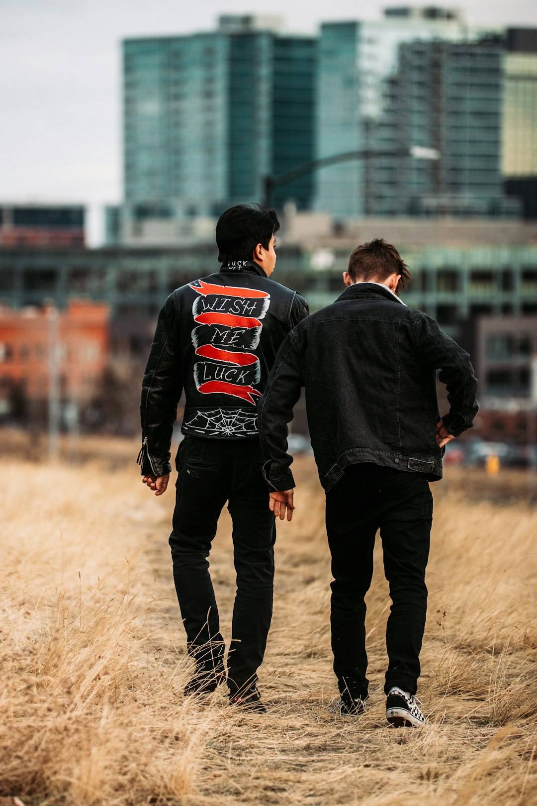 man in black jacket and black pants standing beside man in black jacket during daytime