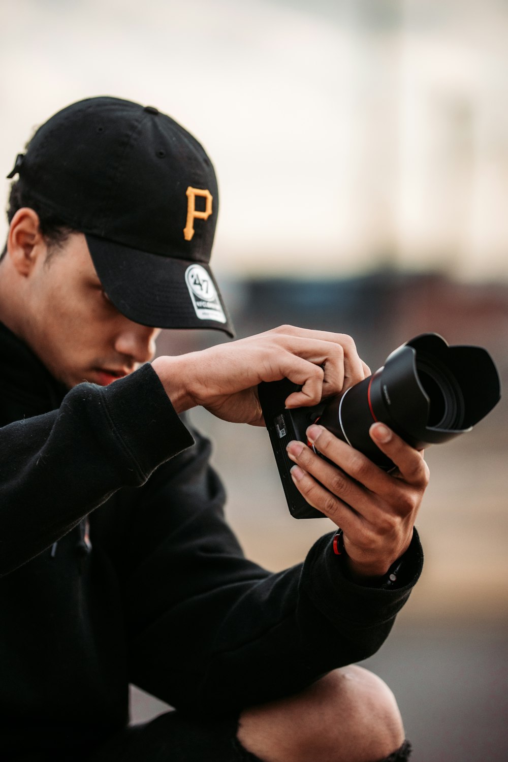 man in black jacket holding black dslr camera