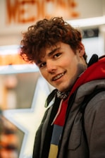 man in black and red jacket smiling