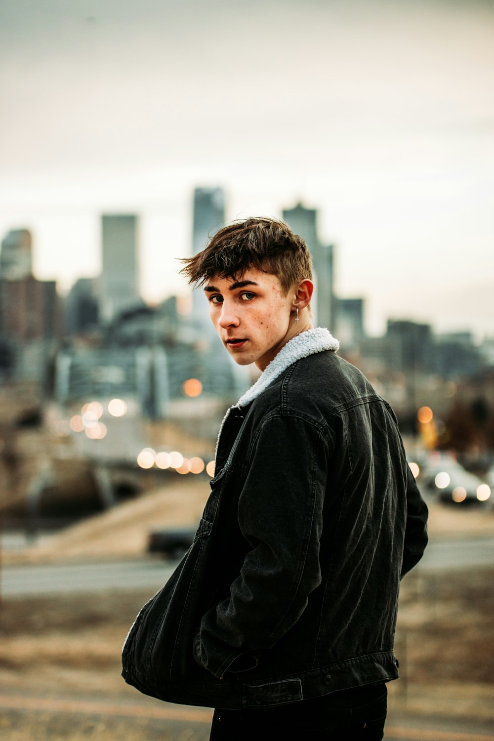 man in black coat standing on road during daytime