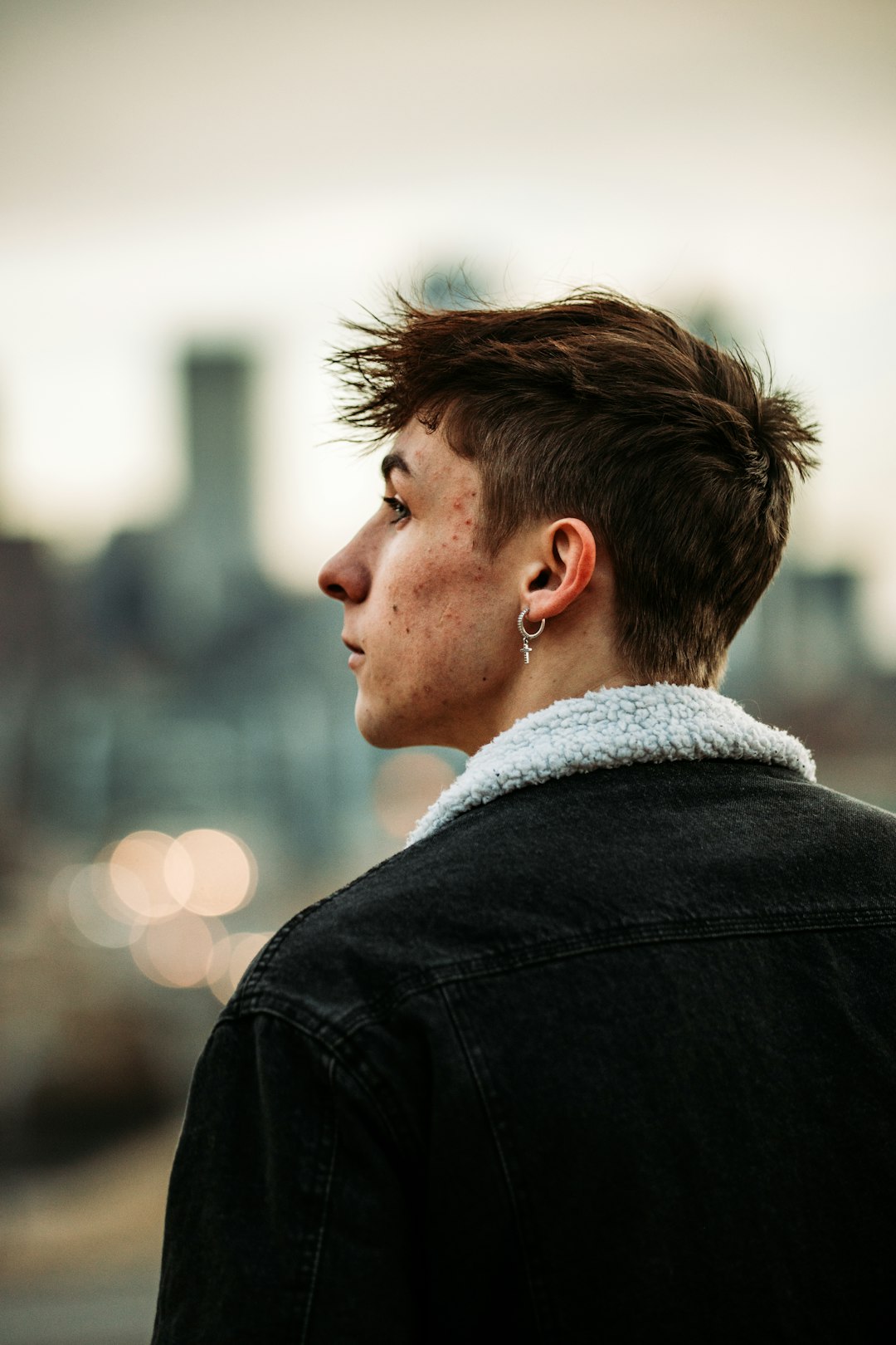 man in black jacket wearing silver earring