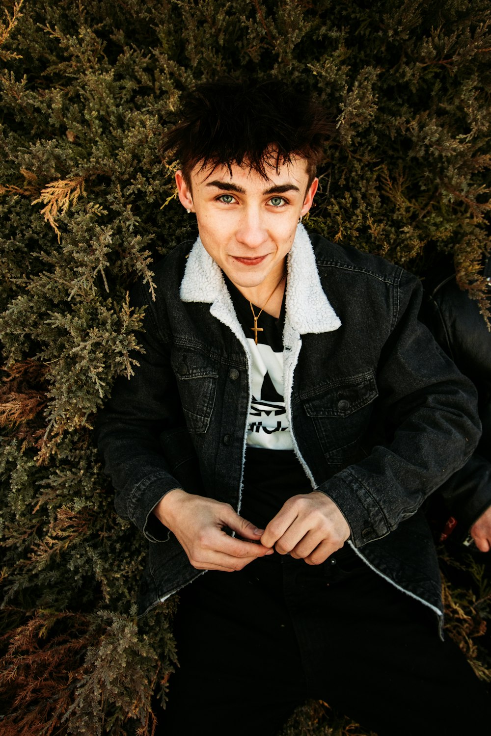 man in black jacket sitting on brown grass