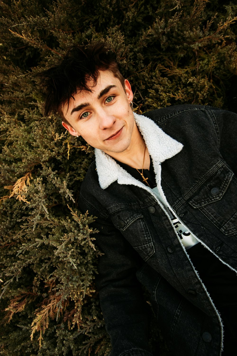 man in black jacket lying on brown grass