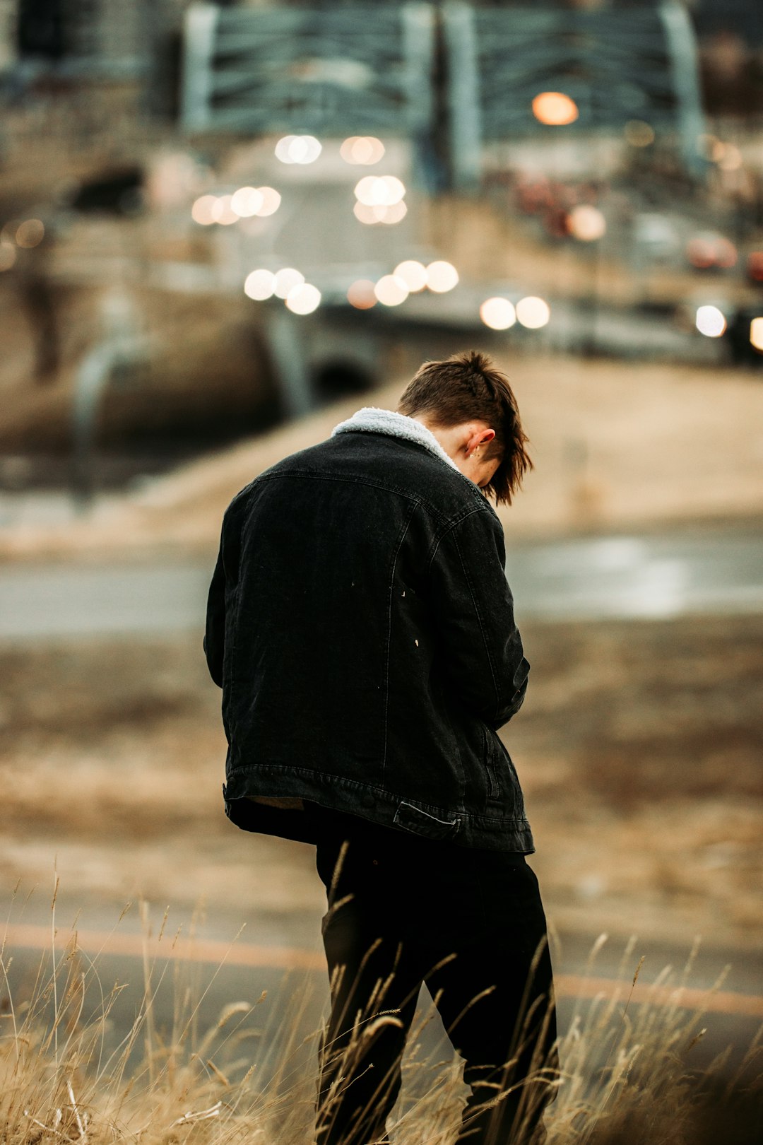 man in black jacket standing on brown field during daytime