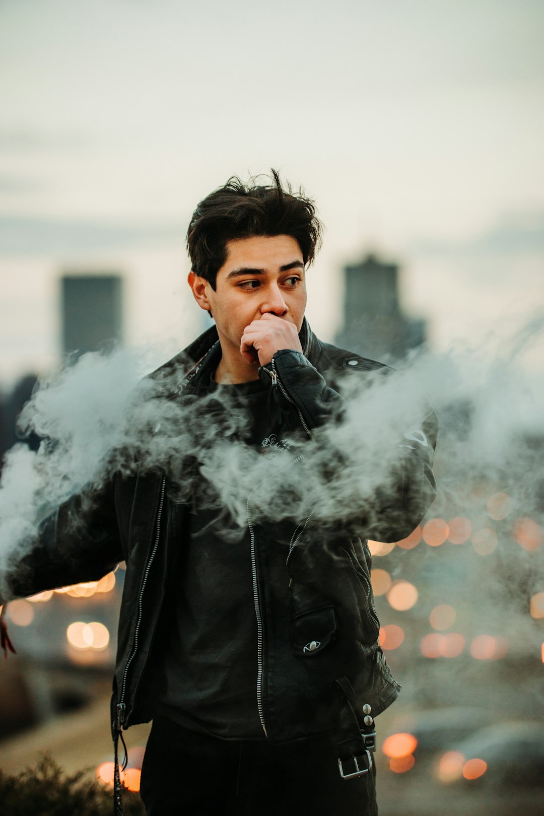 man in black leather jacket smoking