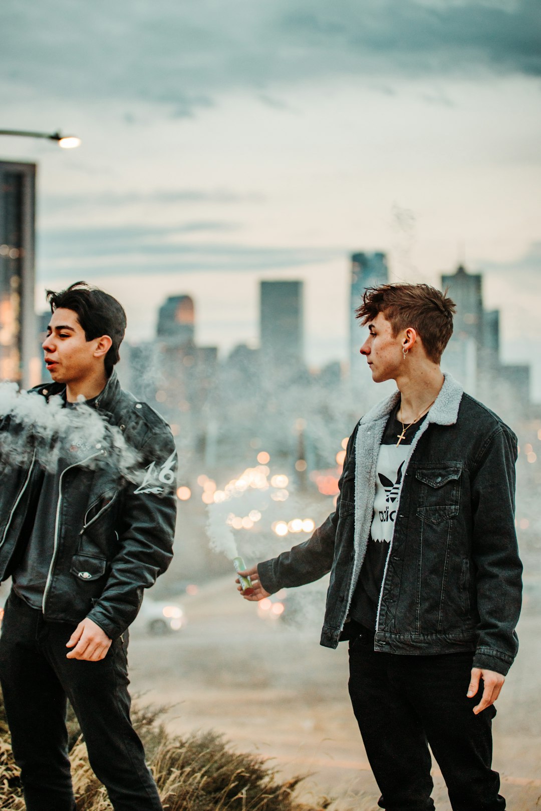 man in black leather jacket holding white smoke