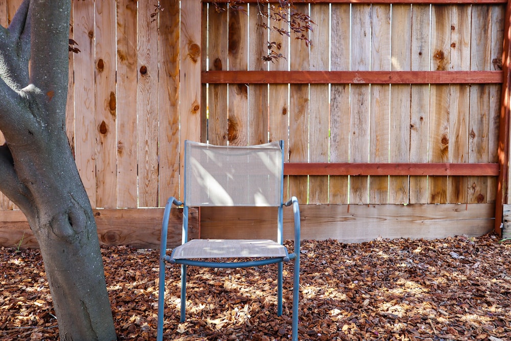 brown wooden armchair near brown wooden fence
