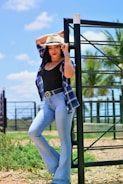 A model wearing a clean-cut western shirt standing against a rustic wooden fence.
