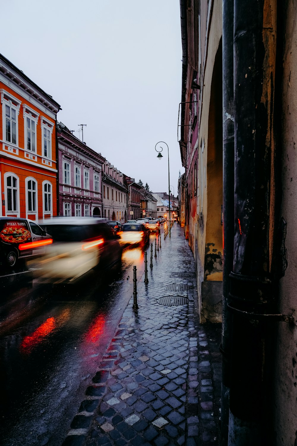 auto sulla strada tra gli edifici durante il giorno