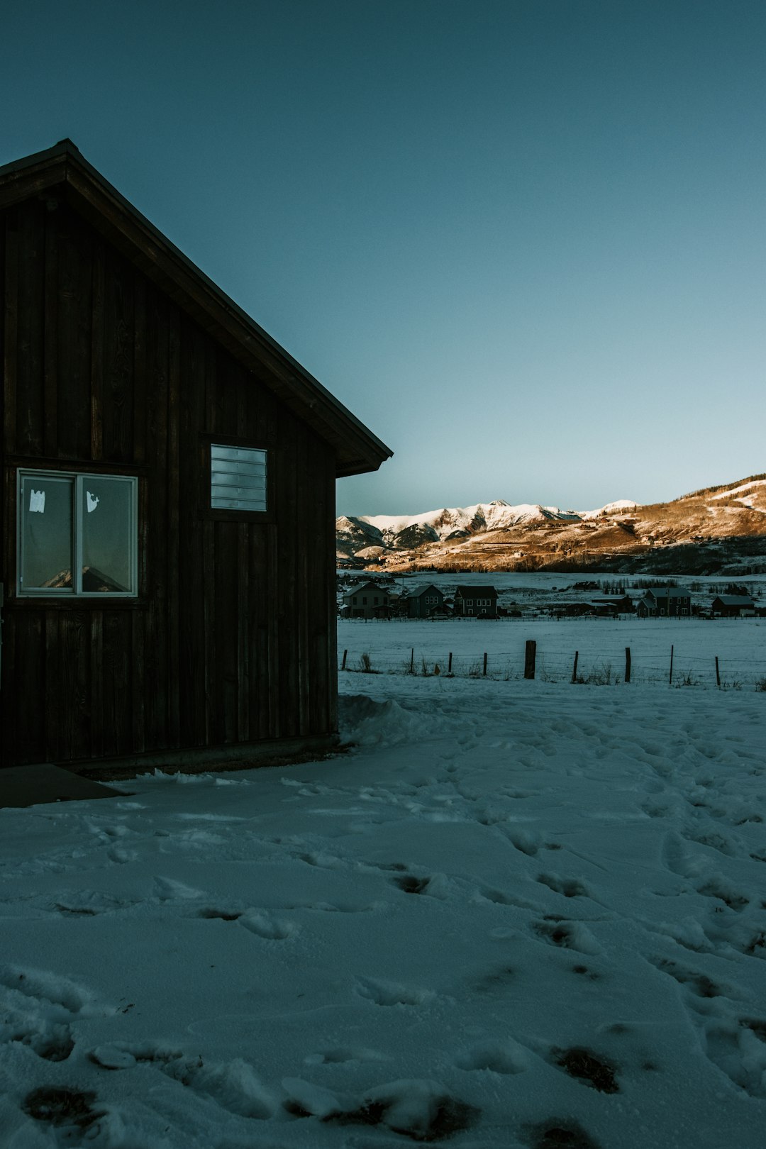 brown wooden house on snow covered ground during daytime