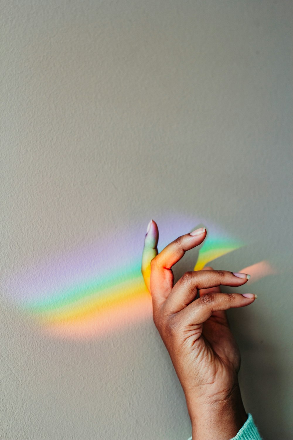persons hand with green pink and yellow light