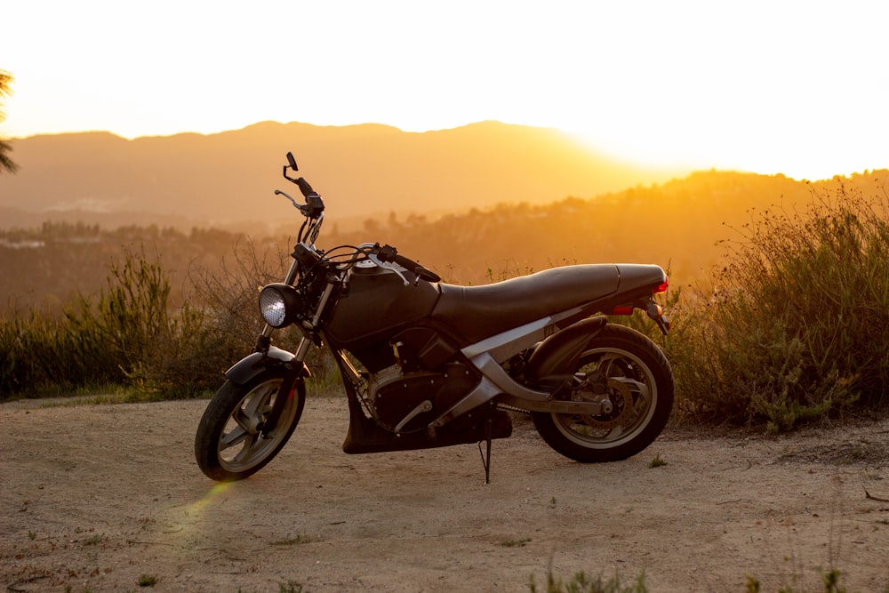 black motorcycle on brown sand during sunset